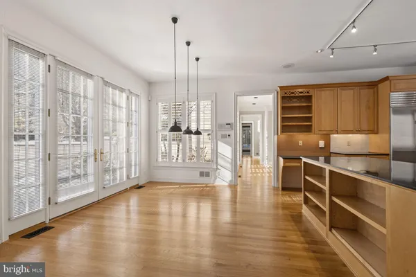 a view of a livingroom with wooden floor and a bathroom