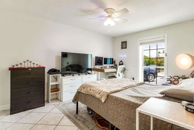a bedroom with a bed a chandelier and a television