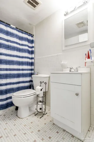 a bathroom with a sink toilet and mirror