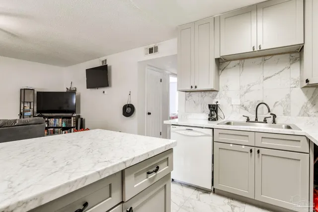 a kitchen with a sink stainless steel appliances and white cabinets