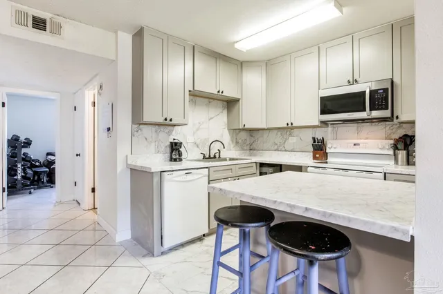 a kitchen with stainless steel appliances a stove a sink cabinets and a refrigerator