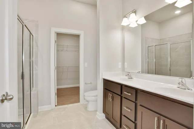 a bathroom with a double vanity sink a toilet and a mirror