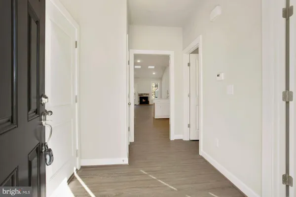 a view of a hallway with wooden floor and closet
