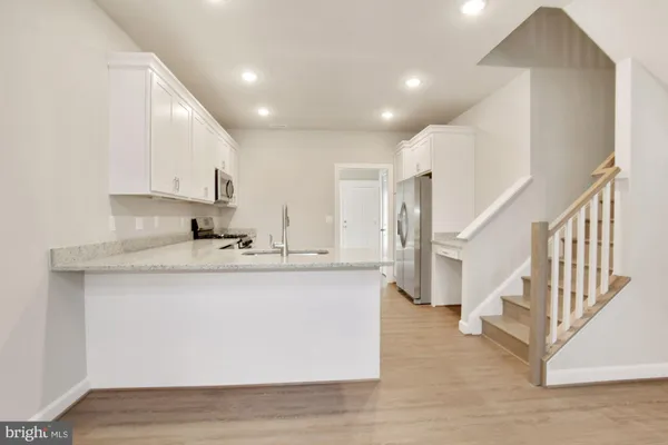 a kitchen with stainless steel appliances granite countertop a sink a stove and a refrigerator