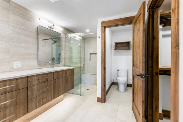a bathroom with a sink toilet a mirror and shower