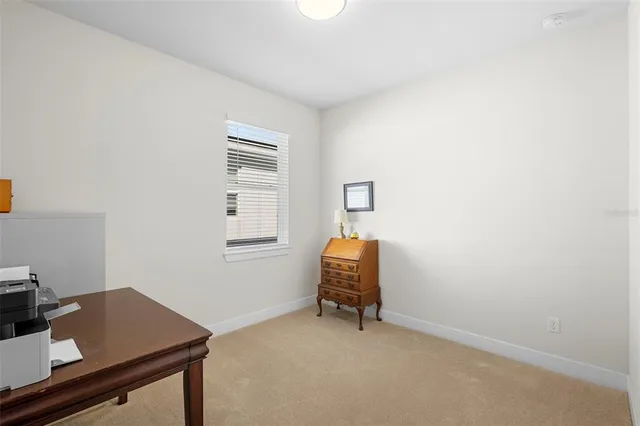 a vase with flowers sitting on a floor in front of a house