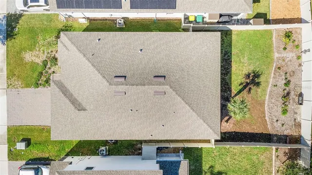 an aerial view of a house with a yard and sitting area