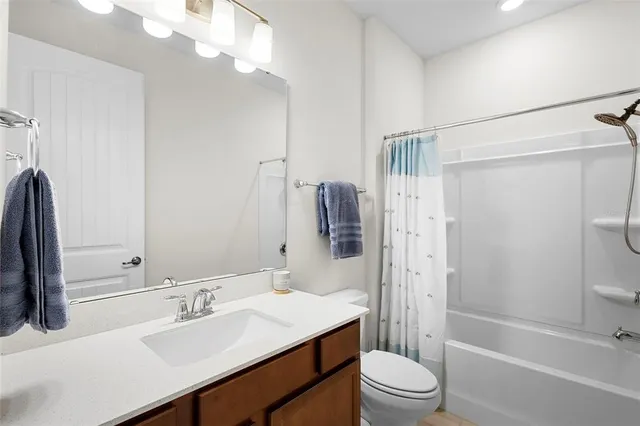 a bathroom with a sink a toilet a mirror a shower and vanity