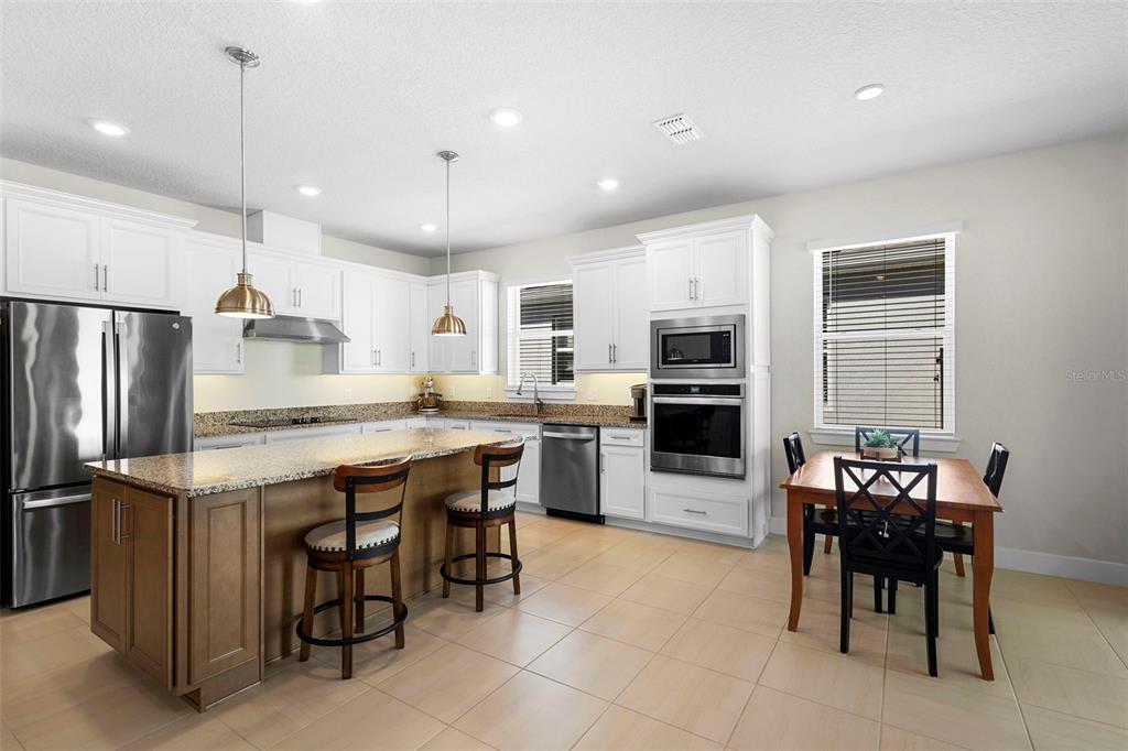 2024 Canopy Terrace Boulevard DeLand, FL 32724 - Photo 10 of 25 a kitchen with kitchen island granite countertop counter space dining table and stainless steel appliances