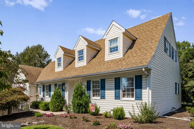 a view of a white house with large windows and a small yard