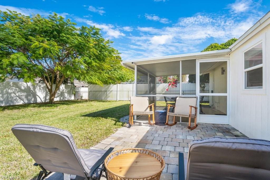 1207 Hernando Street Naples, FL 34103 - Photo 29 of 37 a view of a patio with table and chairs potted plants and floor to ceiling window