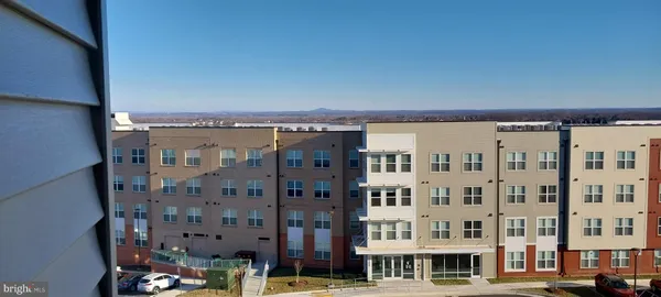 a balcony view with couple of cars parked in front of a building
