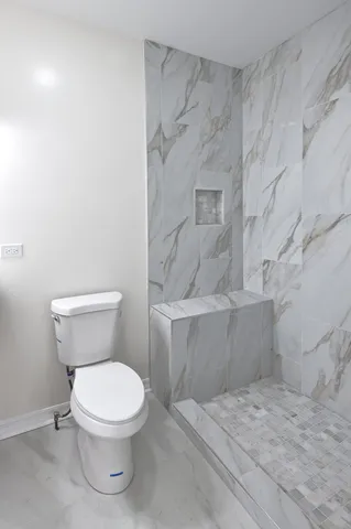 a white toilet sitting next to a bathroom sink