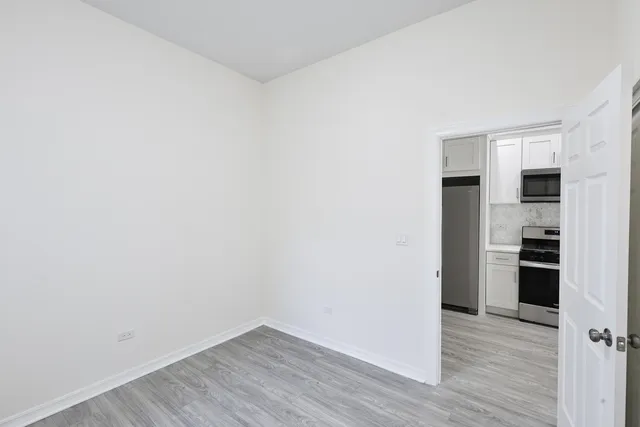 a view of a kitchen with wooden floor and electronic appliances