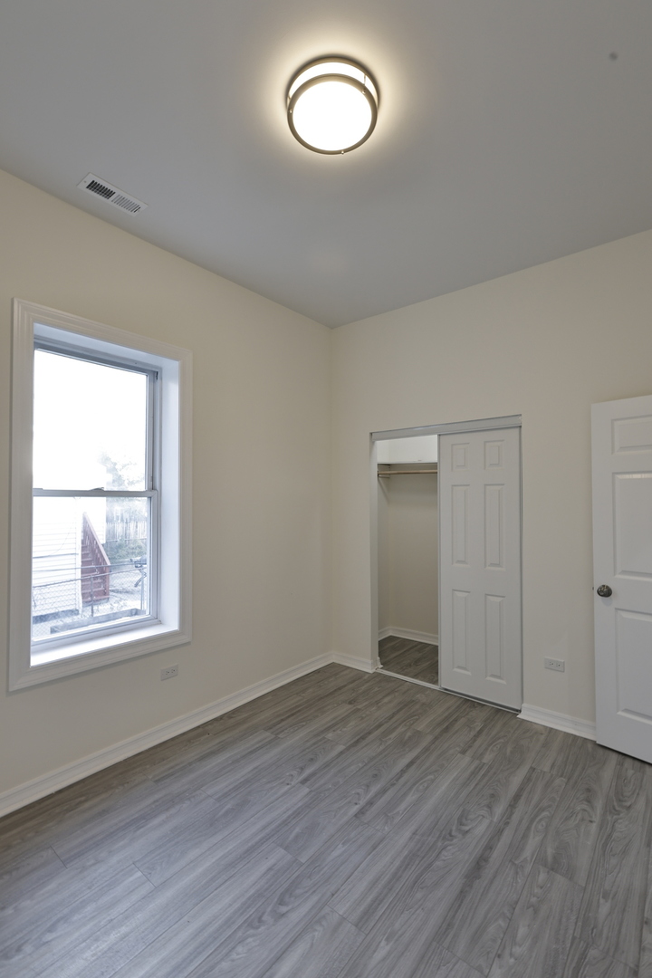 3621 South Winchester Avenue, Unit 1 Chicago, IL 60609 - Photo 18 of 24 an empty room with wooden floor and windows