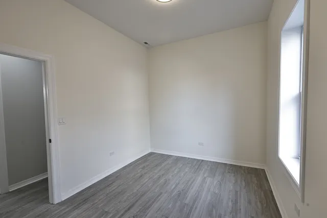 a view of a small space with wooden floor and a window
