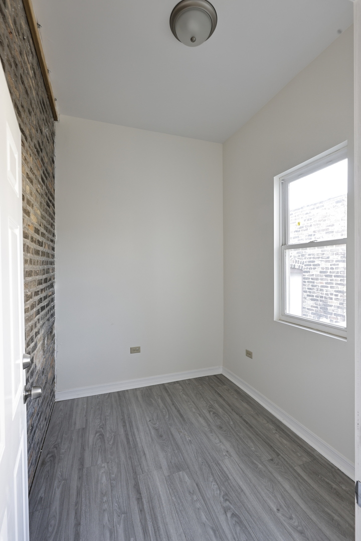 3621 South Winchester Avenue, Unit 1 Chicago, IL 60609 - Photo 21 of 24 an empty room with wooden floor and windows