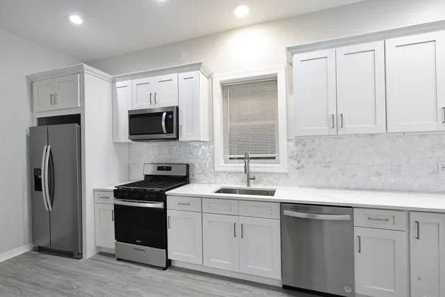 a kitchen with stainless steel appliances granite countertop a sink stove and refrigerator