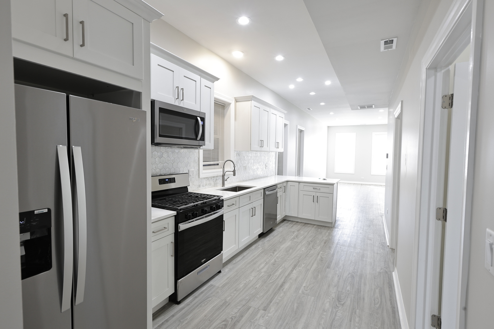 3621 South Winchester Avenue, Unit 1 Chicago, IL 60609 - Photo 7 of 24 a large kitchen with a refrigerator a sink a stove top oven and cabinets