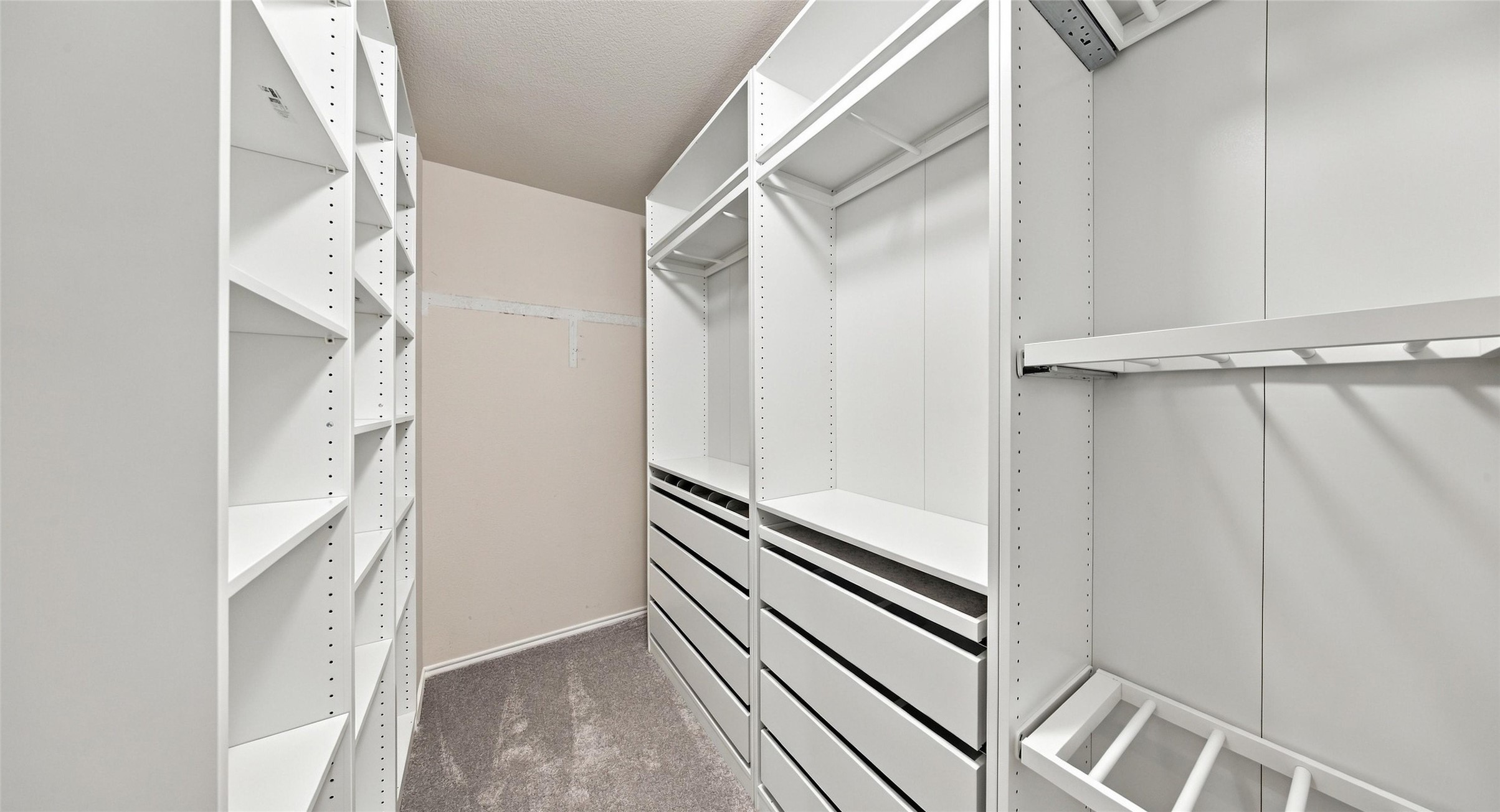 7224 Crestone Road Austin, TX 78744 - Photo 27 of 33 Custom floor-to-ceiling shelving and drawers maximize organization in this plushly carpeted walk-in closet.