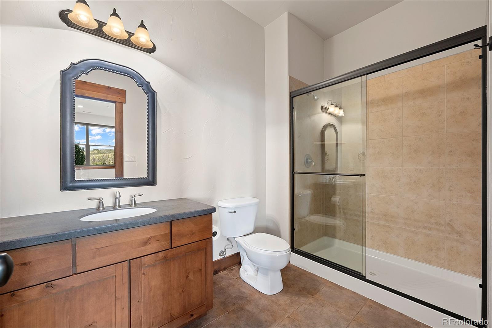 2135 Haystack Road Castle Rock, CO 80104 - Photo 29 of 35 a bathroom with a toilet sink and mirror