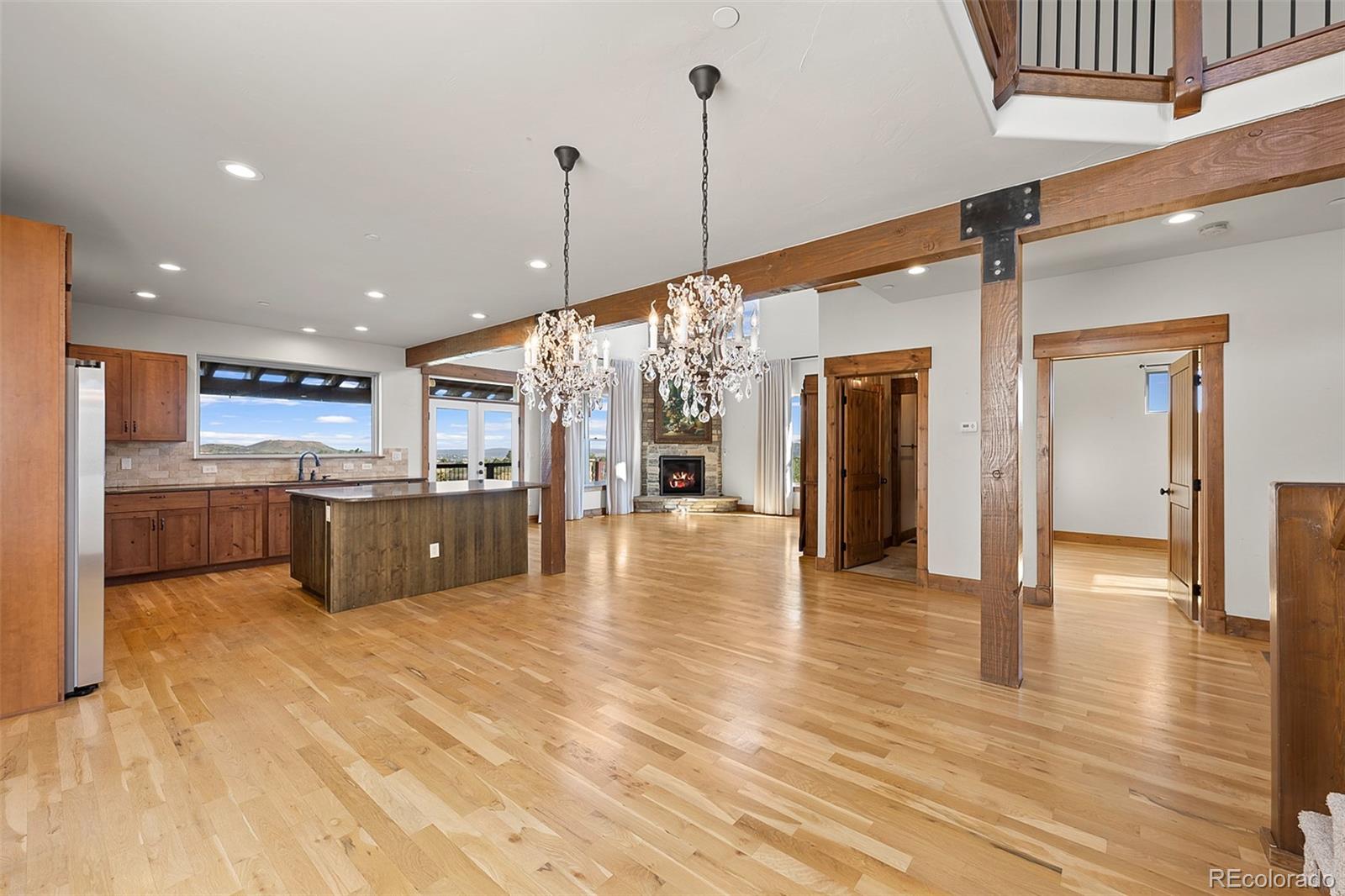 2135 Haystack Road Castle Rock, CO 80104 - Photo 5 of 35 a large white kitchen with a large counter top stainless steel appliances and wooden floor