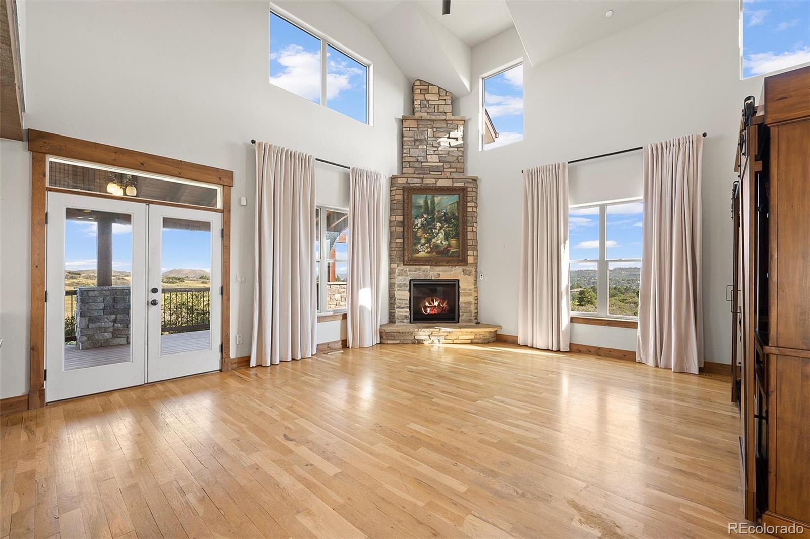 2135 Haystack Road Castle Rock, CO 80104 - Photo 6 of 35 a view of a big room with wooden floor fireplace and windows