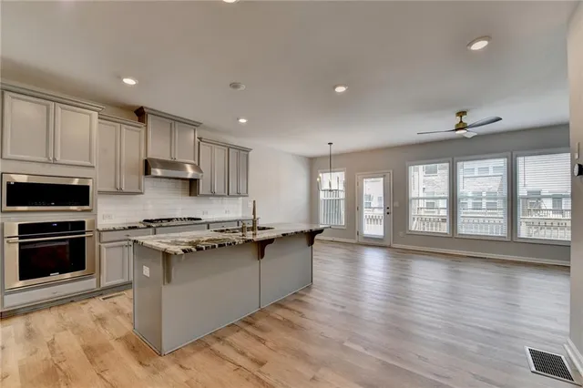 a kitchen with stainless steel appliances granite countertop a sink stove and refrigerator