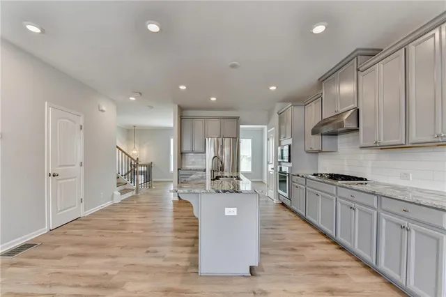 a kitchen with kitchen island granite countertop a stove and a sink