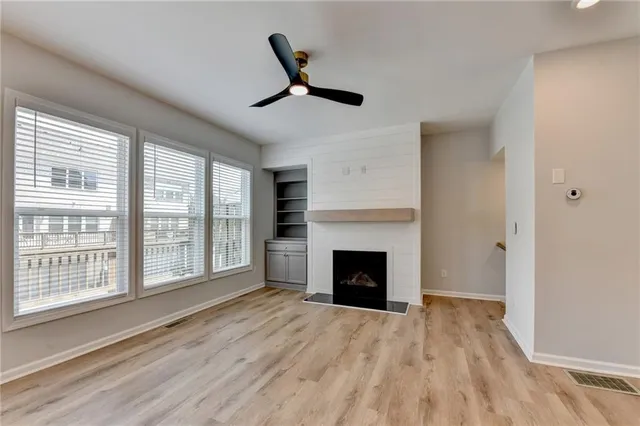 an empty room with wooden floor and windows