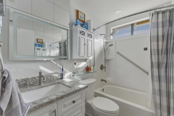 a bathroom with a granite countertop sink toilet and shower
