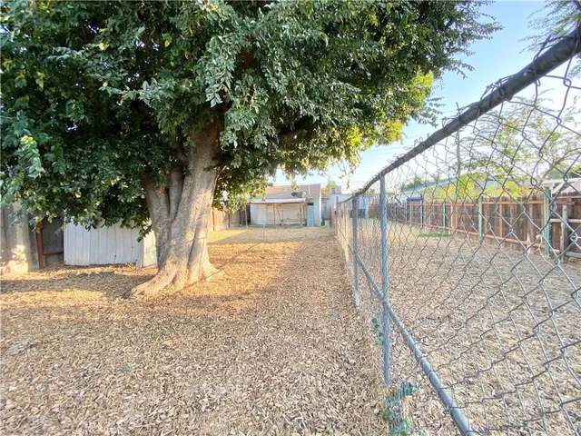 a view of a house with a backyard and a tree