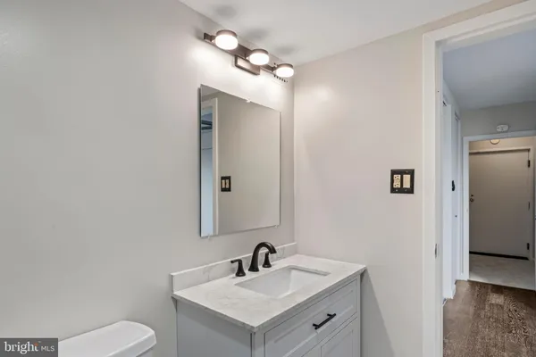 a bathroom with a sink toilet and a mirror