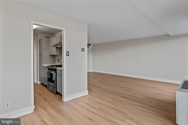 a view of a kitchen with wooden floor and cabinets