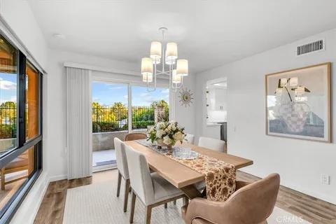 a dining room with furniture a large window and a chandelier