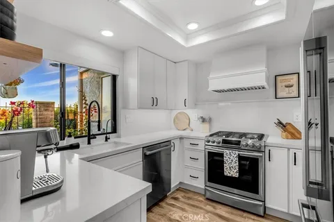 a kitchen with stainless steel appliances a stove a sink and a refrigerator