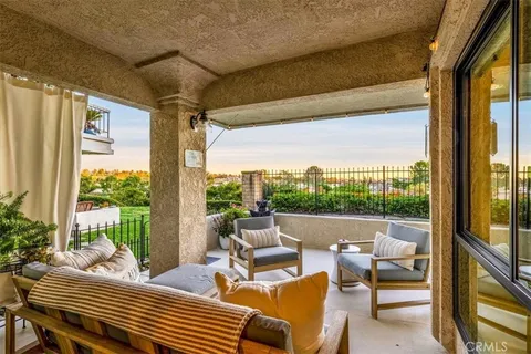 a living room with patio furniture and a floor to ceiling window