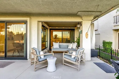 a living room with patio furniture and a potted plant