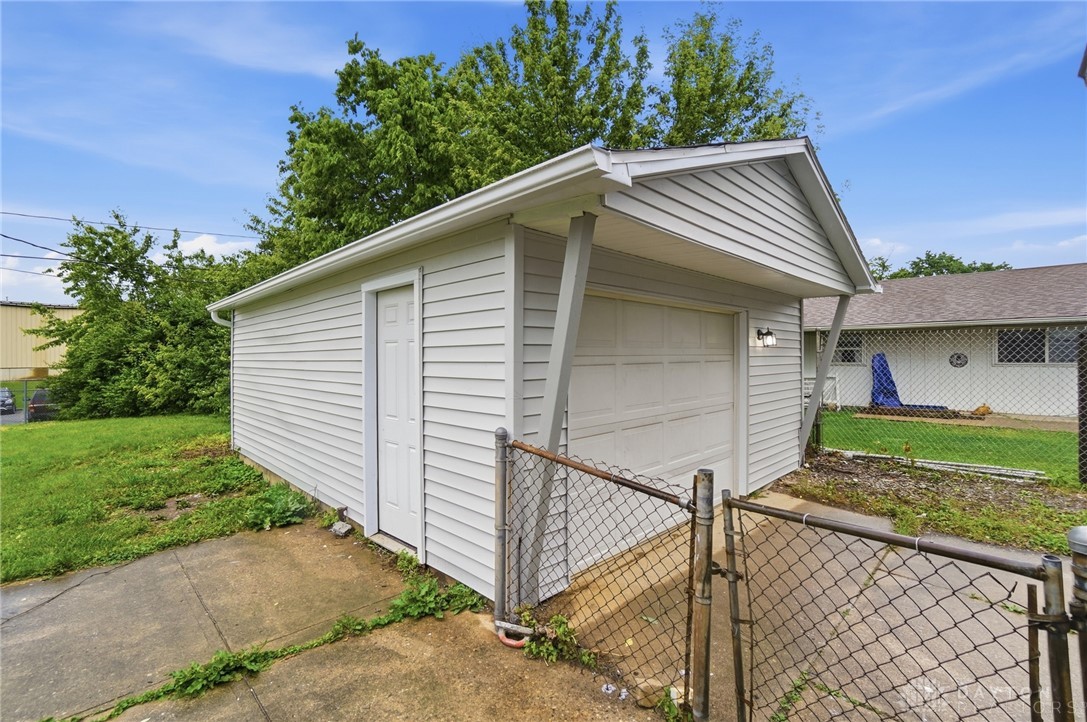 1923 Portage Path Springfield, OH 45506 - Photo 38 of 40 A detached garage with white siding and a service door provides convenient parking and extra storage.