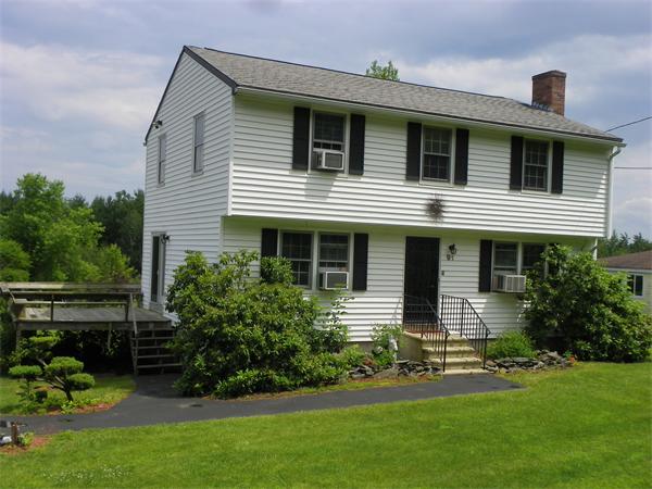 a front view of a house with a garden and plants