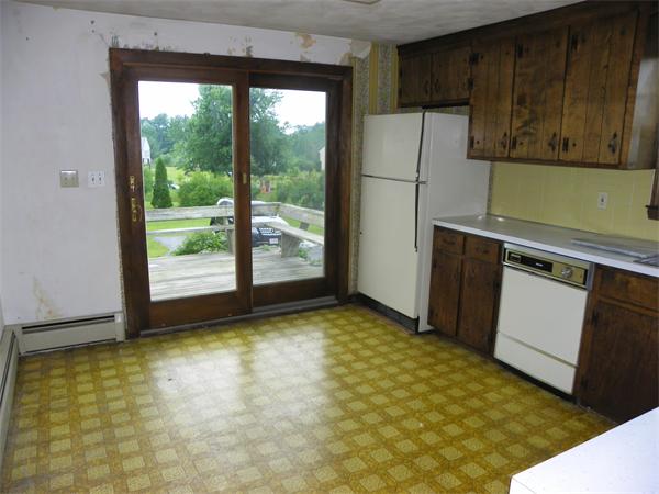 91 Nashua Road Pepperell, MA 01463 - Photo 6 of 14 a kitchen with a refrigerator and cabinets