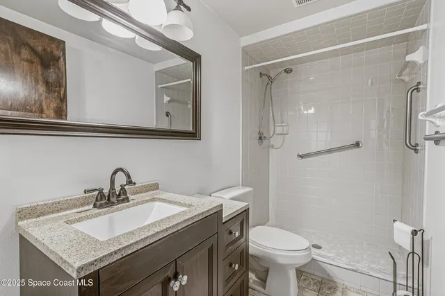 an empty room with chandelier fan and windows
