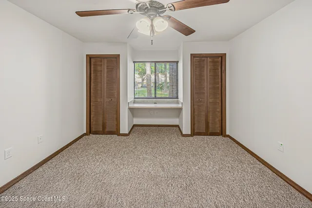 a view of a room with a ceiling fan and a window