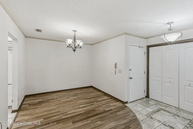 a view of a room with wooden floor and chandelier