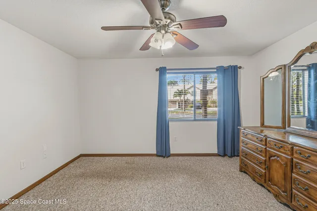 a view of an empty room with closet and mirror