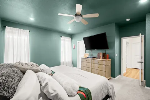 a bedroom with a large bed and a flat screen tv