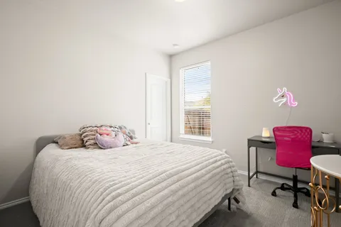 a bedroom with a bed and a chair with the potted plant