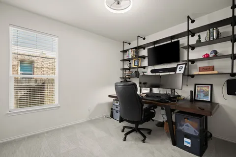 a view of a workspace with furniture and a window