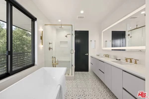 a bathroom with a tub sink and mirror