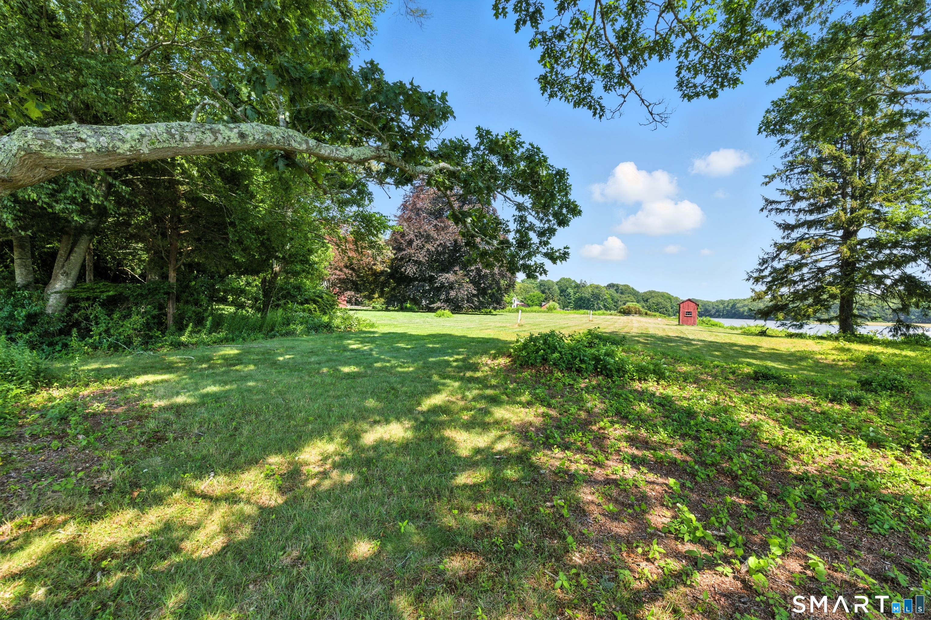 82 Cove Road Stonington, CT 06378 - Photo 7 of 20 a view of a grassy field with trees